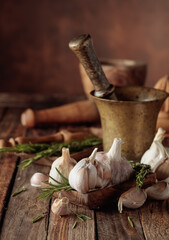 Fresh garlic bulbs with rosemary on a wooden table.