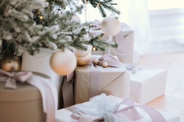 Elegant white and gold Christmas presents under a decorated holiday tree