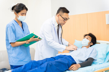 Obraz premium Health care professional conducts a medical checkup on a reclined, patient male and a caregiving nurse records observations, patient care services with specialist doctor using a stethoscope in clinic
