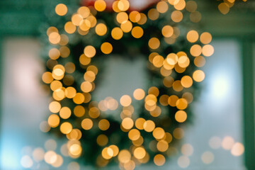 Festive Christmas wreath adorned with dazzling bokeh lights in a cozy setting
