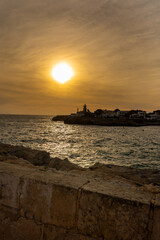 Sunset over the sea and cliff at Cala Blanca, Menorca, Spain
