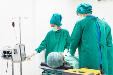 Group of surgical team in green scrubs preparing patient for operation, checking medical equipment. Focus on teamwork, expertise, and care in sterile clinical hospital room, ensuring patient safety