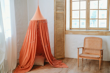 Cozy children’s reading nook with a tent in a softly lit room