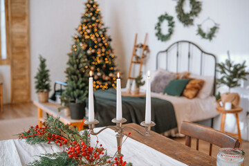 Cozy holiday bedroom setting with a decorated tree and festive table decor