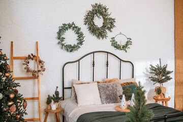 Cozy bedroom decorated with festive wreaths and holiday accents