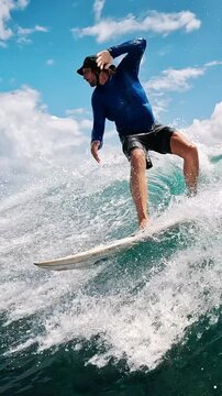 Male pro surfer rides the wave and makes smooth turns. Camera follows the rider