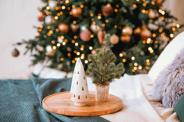 Cozy bedroom with Christmas decorations and a small tree on a nightstand