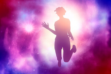 Silhouette of female figure placed against a deep space night sky celestial universe background. Happy woman jumping and enjoying life feeling happy and freedom.