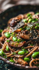 Fototapeta premium A vertical close-up of Asian-inspired black truffle pasta with soba noodles in soy ginger sauce, featuring edamame, grilled shiitake mushrooms, nori strips, and sesame seeds.