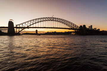 Picturesque view on Sydney Harbor Bridge at sunset. The bridge was opened in 1932 and it is the...