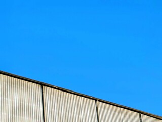 Aluminum corrugated industrial warehouse metal wall surface building on against blue sky background