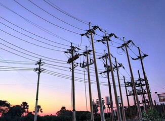 Electric poles and power lines at sunset time