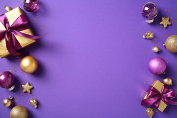Christmas decorations on a purple background with golden and purple baubles, star-shaped ornaments, and wrapped gifts. Flat lay, top view, copy space.