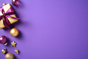 Elegant Christmas decor on a purple backdrop featuring golden and purple ornaments, a gift box, and confetti. Ideal for festive designs and seasonal celebrations