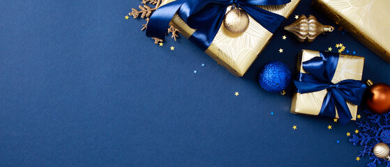 Christmas banner design. Xmas Gifts wrapped in elegant gold paper with blue ribbons on dark blue background