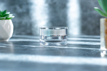 clear cream jar on the grey surface with overlay shadow, use for beauty mockup product