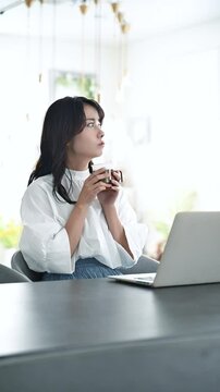 パソコンをしながら上向いて考える若い女性　　転職や退職などを考える女性の落ち込む、不機嫌なスローの縦動画	　もう転職しようかな～
