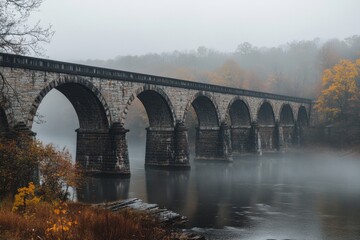 Fototapeta premium Bridges Over a Foggy River: A historic bridge arching over a slow-moving river