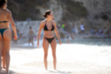 Obraz premium Summer vacation, silhouettes of women playing on the beach. Defocused, blurred image of beach