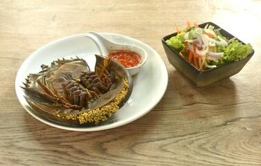 spicy and sour sea horseshoe crab egg wiith slice vegetable salad Thai food on plate