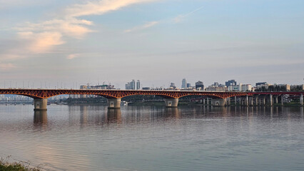 Obraz premium 서울의 한강에서 노을지는 하늘과 불빛이 반짝이는 교량이 있는 도시 경관