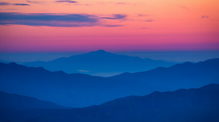 Obraz premium Vibrant sunrise illuminating mountain ranges in a serene landscape during early morning hours