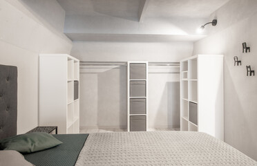 Wide Angle of Loft Home Bedroom Interiom. King Size Double Bed. White Walls. Family Home. Shelf and Closet in Backgrond