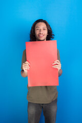 young man holding an empty red colored poster. Confident and looking at camera.