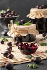 Homemade gooseberry jam in transparent bowl and in jars