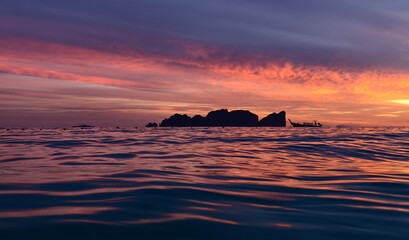 A stunning sunset is casting vibrant hues of color over a tranquil ocean