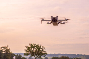 A drone flies over the countryside as the sun sets
