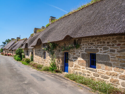 Charming breton Stone Cottages with Thatched Roof and Blue Shutters in the traditional village of Kercanic