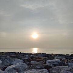 Fototapeta premium Serene Sunrise over Ocean Rocks Calm Coastal Scene