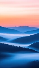 Obraz premium A serene landscape showcasing layered blue hills under a pastel sunset, with fog creating a dreamy atmosphere.