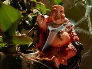 Smoke from an aroma bomb during meditation on the background of a Buddha and an orchid