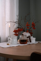 A Cozy Table Setting That Incorporates Beautiful Autumn Decor and Warm Candlelight Shadows