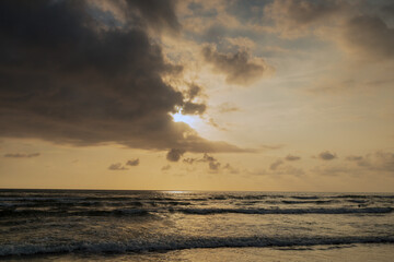 Obraz premium Stormy sea. Sunset with clouds and a light of colors. Water wind and sun. Seascape