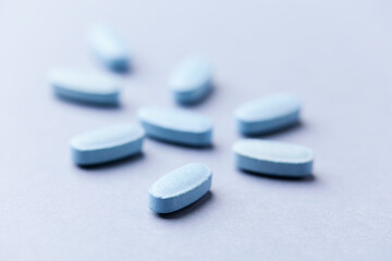Multivitamin tablets on bright paper background. Close up. Copy space.	