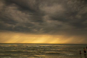 Mare in tempesta. Tramonto con nuvole e una luce di colori. Acqua vento e sole. Paesaggio marino