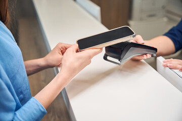 Hands exchanging a card at the reception desk