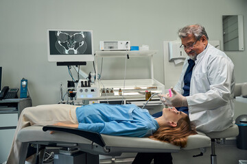 Doctor conducting procedure on patient lying on table