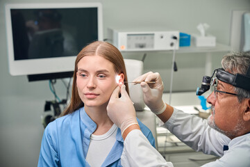 Female patient undergoing ear examination by doctor