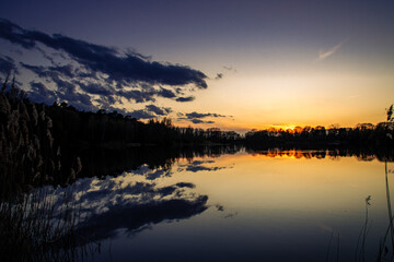 Sonnenunterng am See mit dramatischen Himmel 