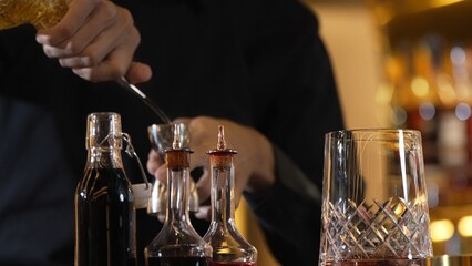 Closeup hand bartender holding jigger to measure liquor sugar into mixing glass ingredients alcohol preparation creative mixed cocktail. Special refresh drink showcasing nightlife mixology. Vinosity.