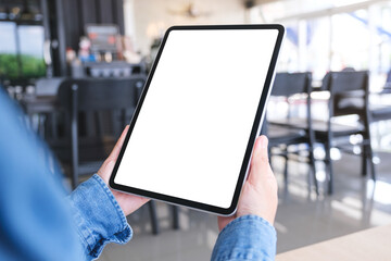 Mockup image of a woman holding digital tablet with blank desktop screen in cafe