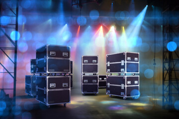 Concert equipment in transport boxes. Containers on wheels on stage. Flightcase under spotlights....