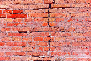 Texture of brick wall, it can be used as a background. Brick texture with scratches and cracks. Brick wall featuring a noticeable crack running through the surface