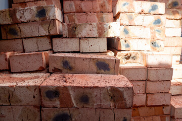 Red bricks stacked on a construction site close-up. Building stone prepared for construction