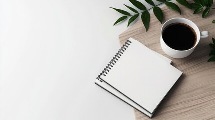 A cozy workspace scene featuring a blank notebook, a coffee cup, and green leaves, ideal for note-taking or brainstorming.