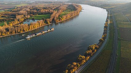 Binnenschiff auf dem Rhein bei Nierstein – Herbstliche Weinberge in Rheinland-Pfalz